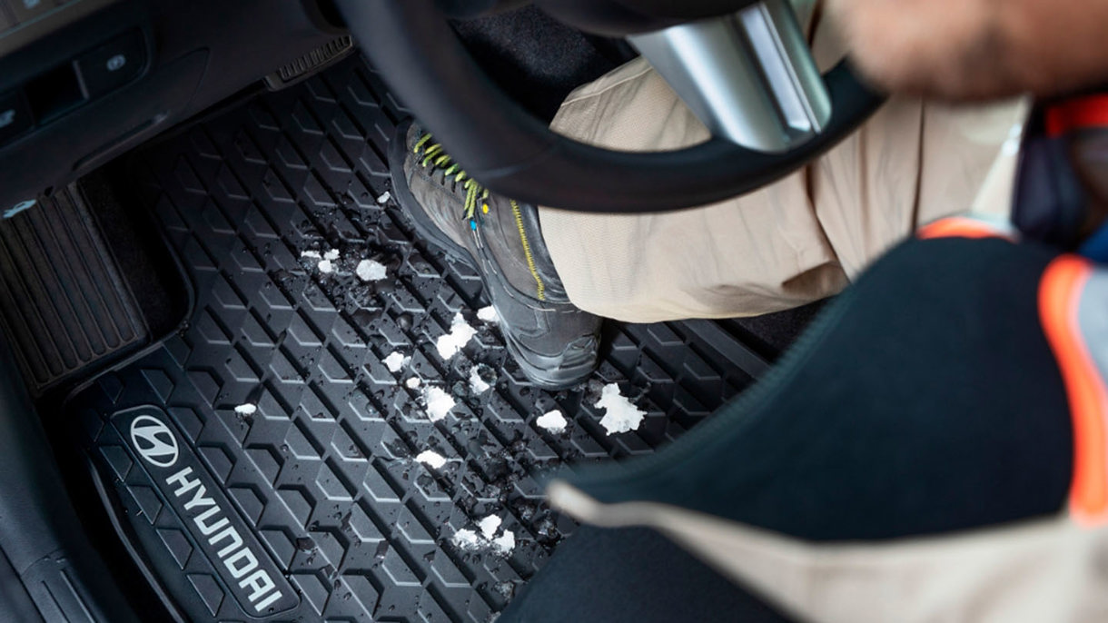 Person med sne på skoene træder ind i Hyundai med gummimåtter