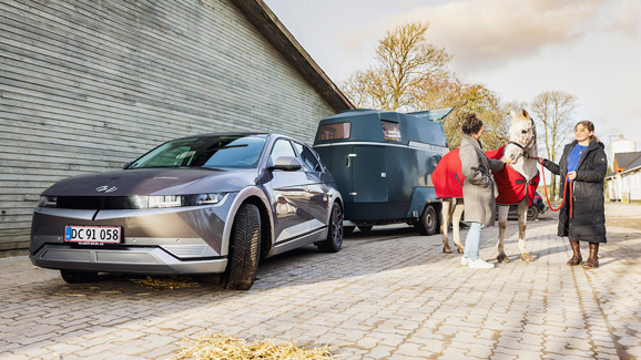 Mor og datter med hest foran Hyundai IONIQ 5 med hestetrailer på anhængertrækket