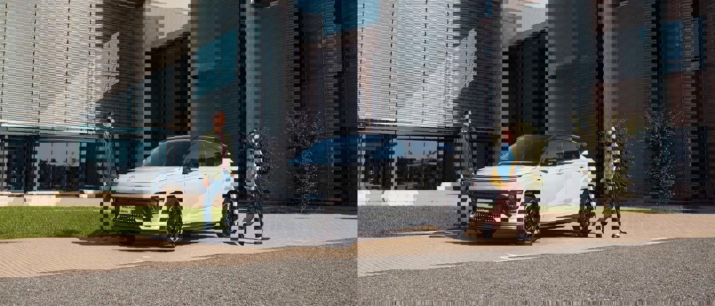 Kvinde og mand går foran KONA EV