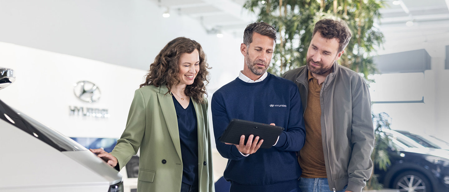 Mand og kvinde får hjælp af en Hyundai medarbejder