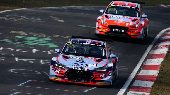 To Hyundai-biler på banen under en Touring Car Racing-afdeling.