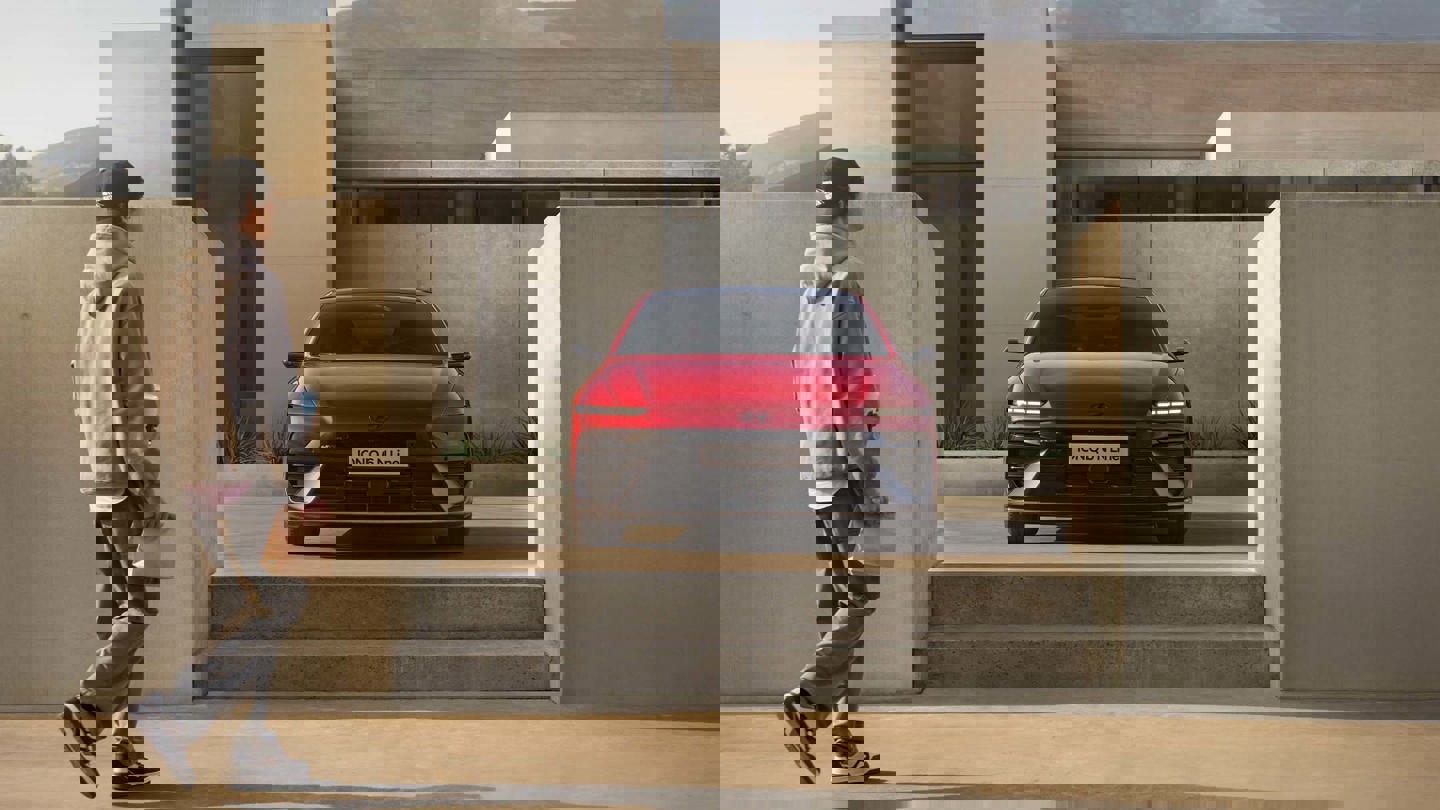 Den nye Hyundai IONIQ 6 N-line i rød der holder ved et hus