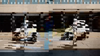 Kvinde går væk fra Hyundai INSTER med mobil i hånden 