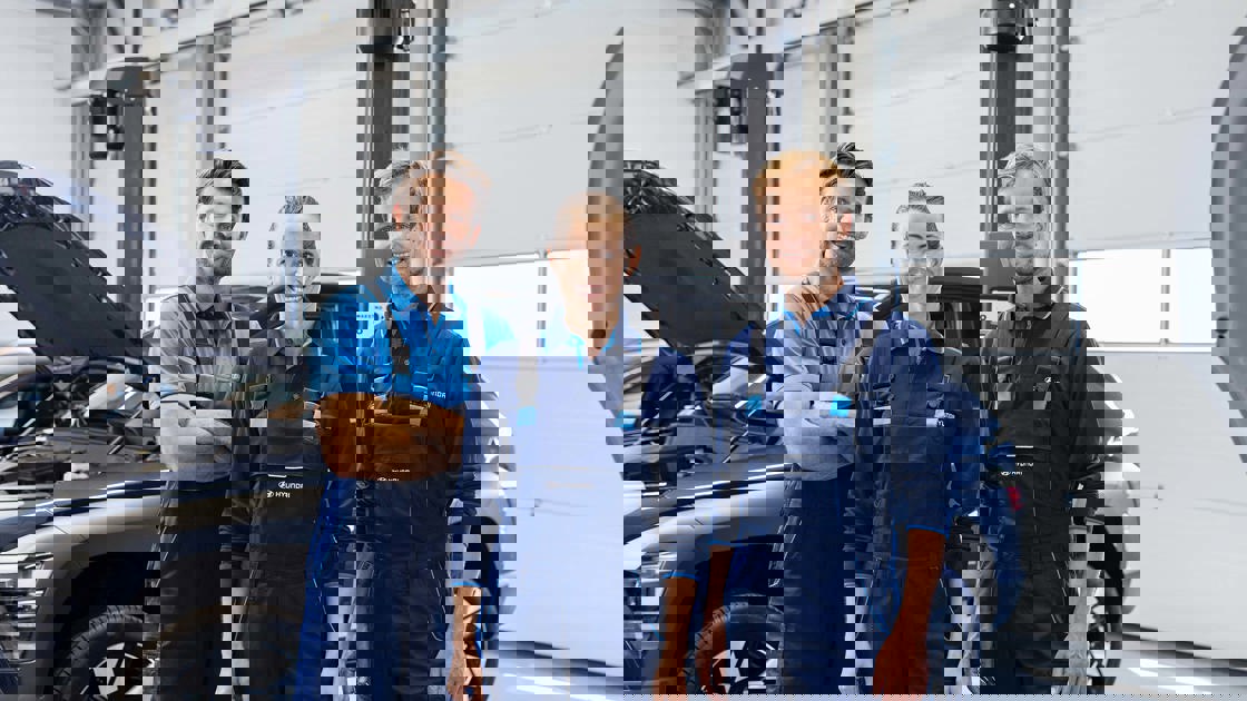 Tre Hyundai-mekanikere står foran bil