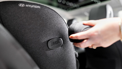 Kvinde er ved at spænde autostol fast i bil 