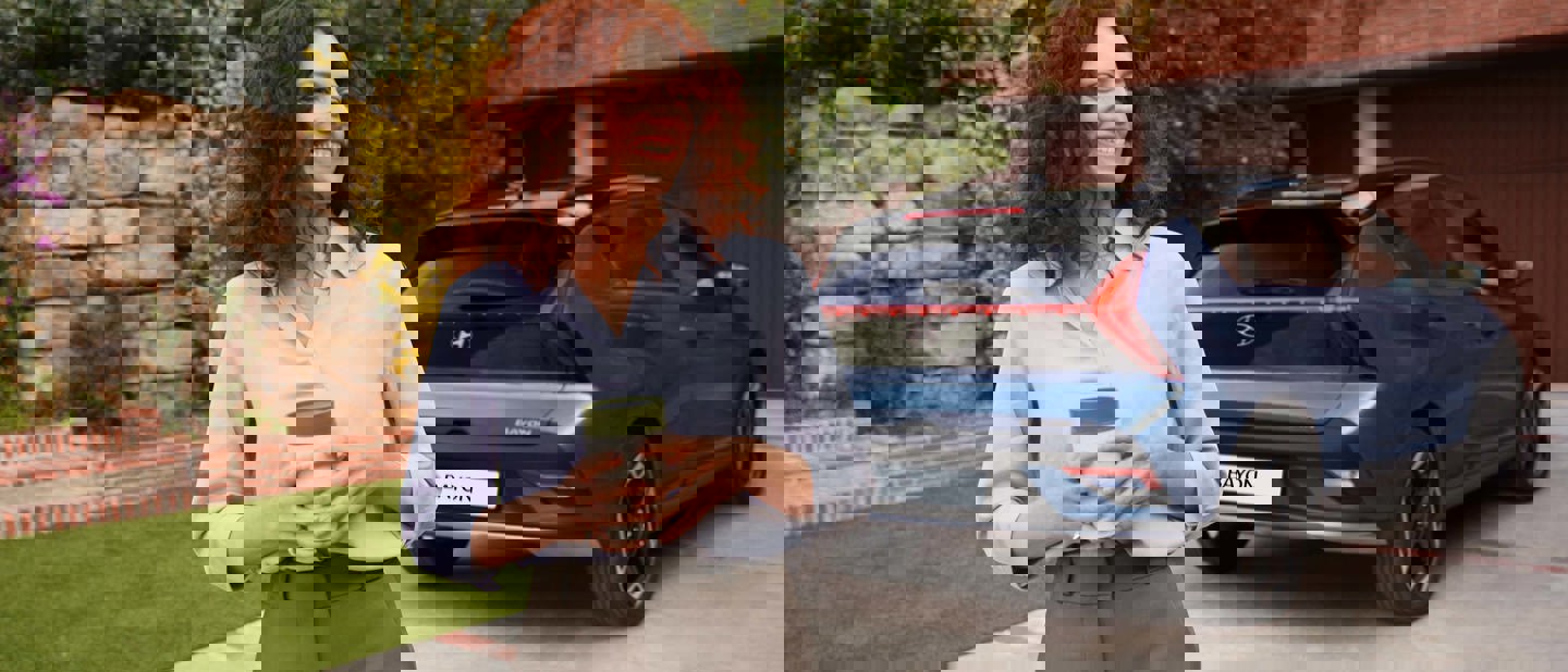 Dame der står ved hendes Hyundai BAYON