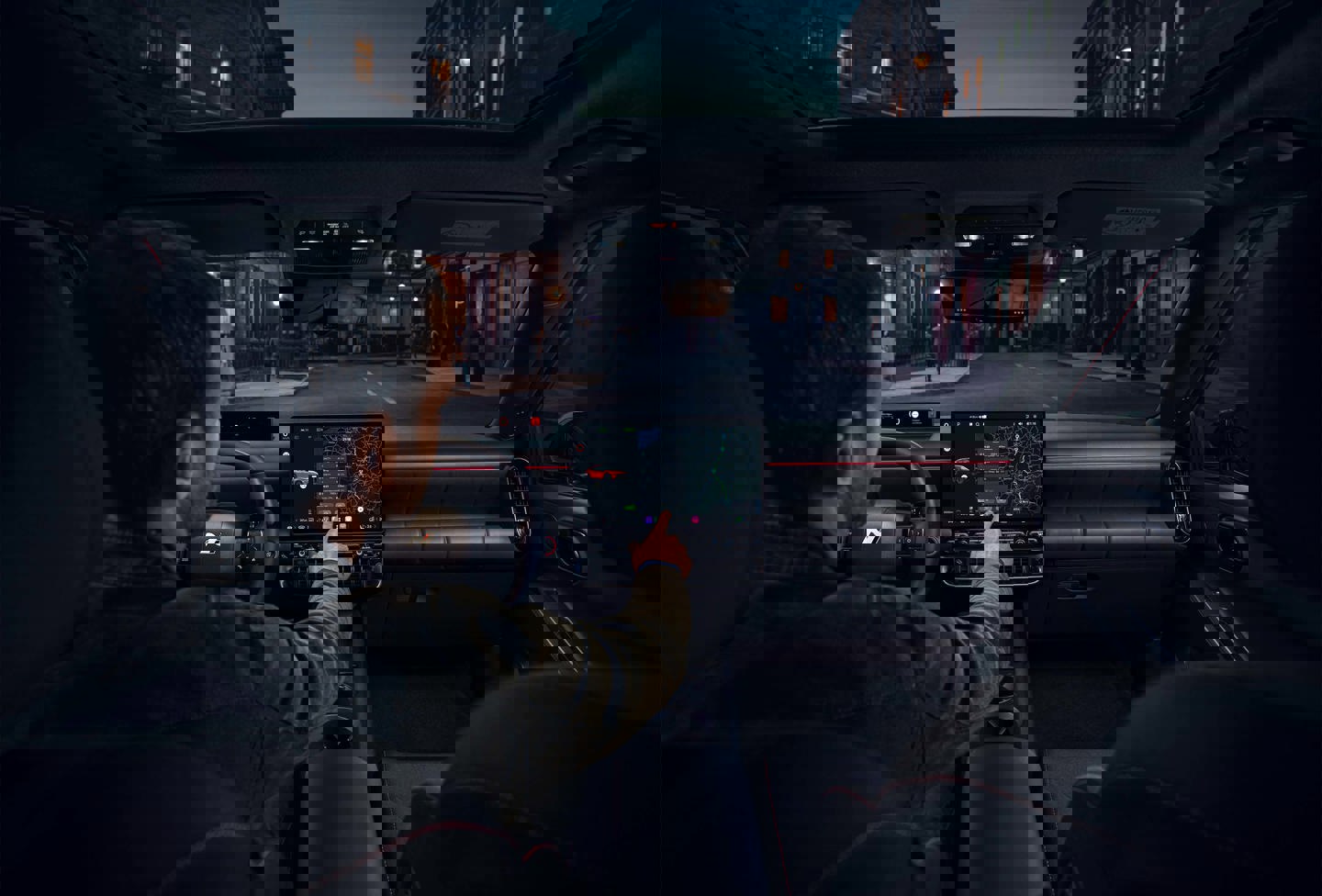 En person cykler langs en solrig bygade med høje bygninger og parkerede biler langs kantstenen.