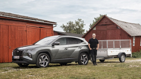 Hyundai-ejer ved siden af sin Hyundai TUCSON Plug-in Hybrid med trailer på anhængertrækket