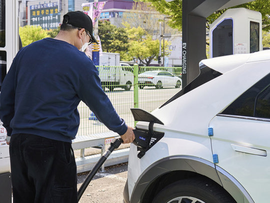 Mand sætter ladekabel i sin Hyundai Elbil
