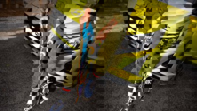 Kvinde sidder med skateboard på kølerhjelmen af Hyundai i20